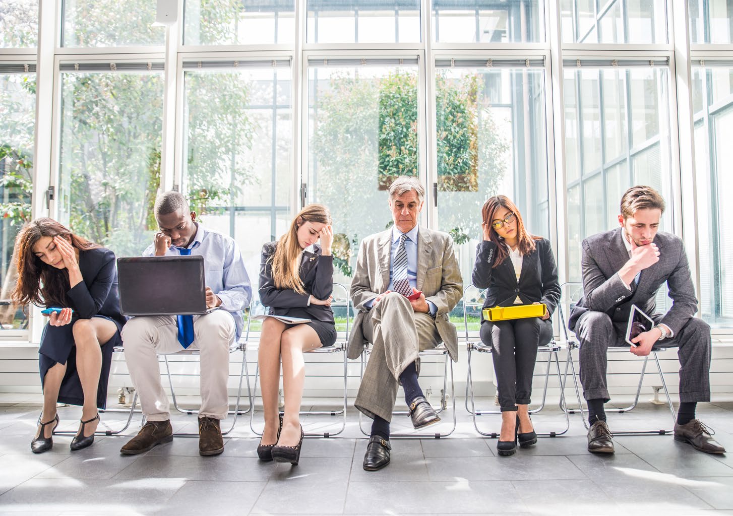 Una fila de candidatos esperando en el vestíbulo de una oficina antes de las entrevistas