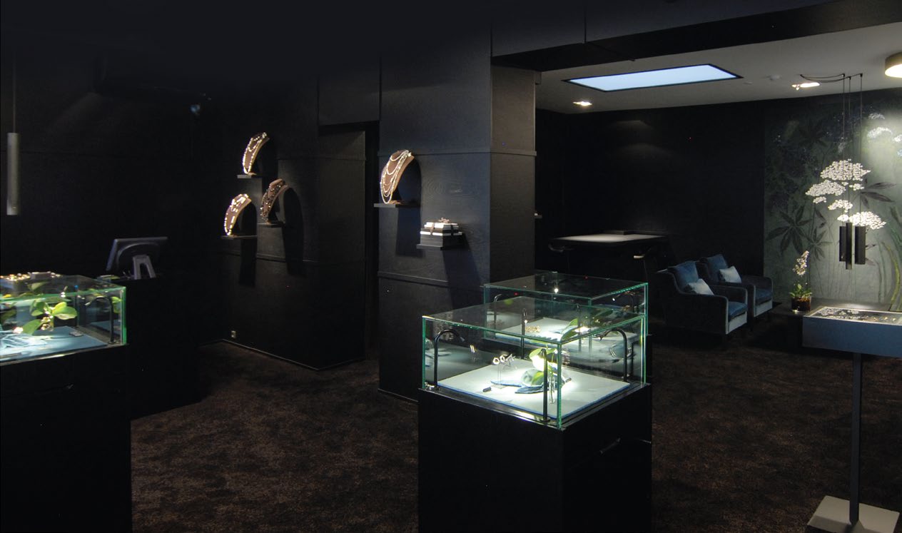 Lit glass display cases holding jewellery in a dark showroom