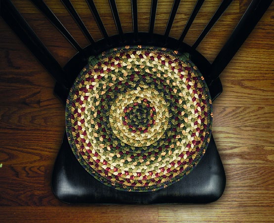 Une galette de chaise ronde tressée posée sur une chaise en bois sombre