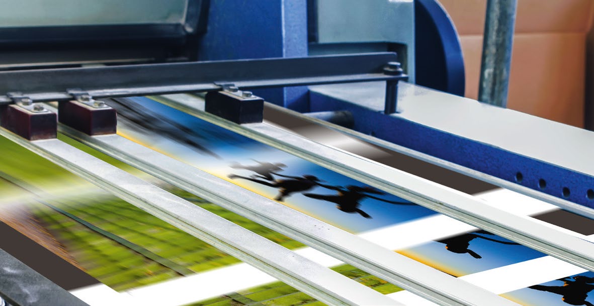 Printed sheets running through a press on parallel belts
