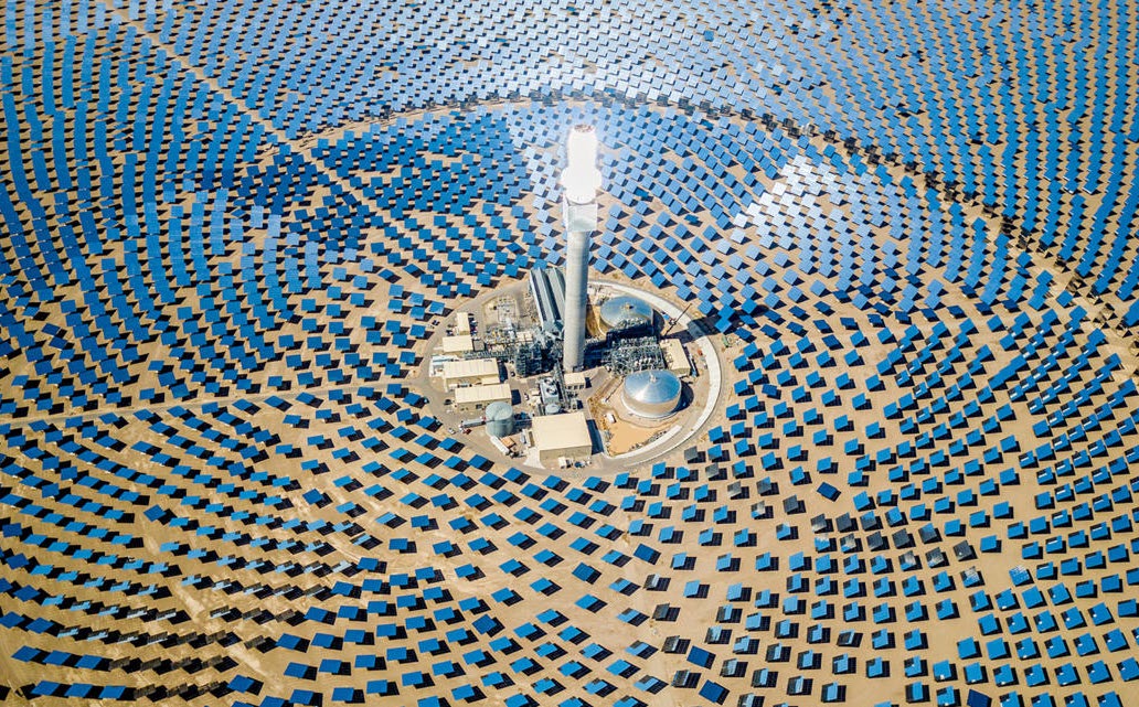 Vista a&eacute;rea de una central solar t&eacute;rmica con miles de espejos alrededor de una torre central