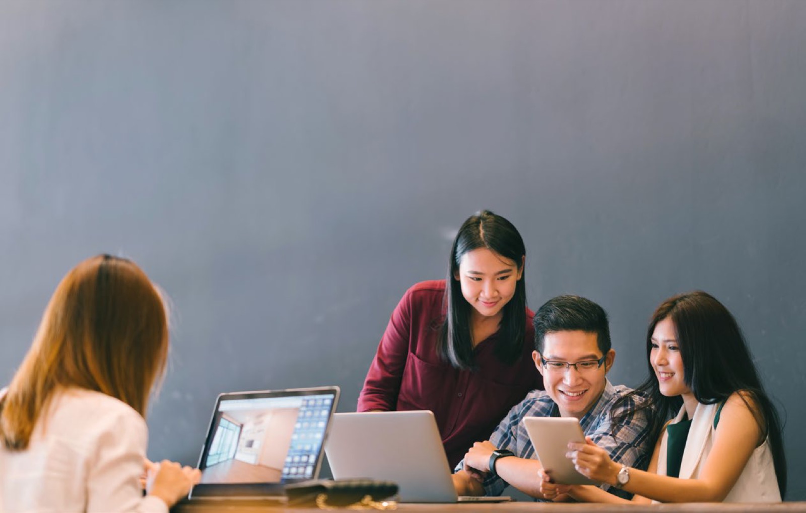 Une équipe réunie autour d’ordinateurs portables et d’une tablette examine des données