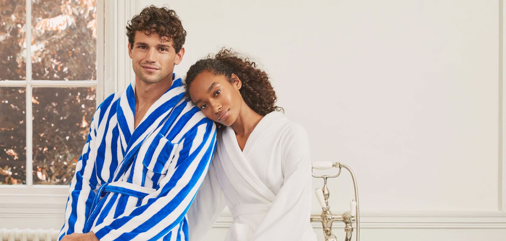 Deux personnes en robes de chambre Derek Rose dans une salle de bains lumineuse