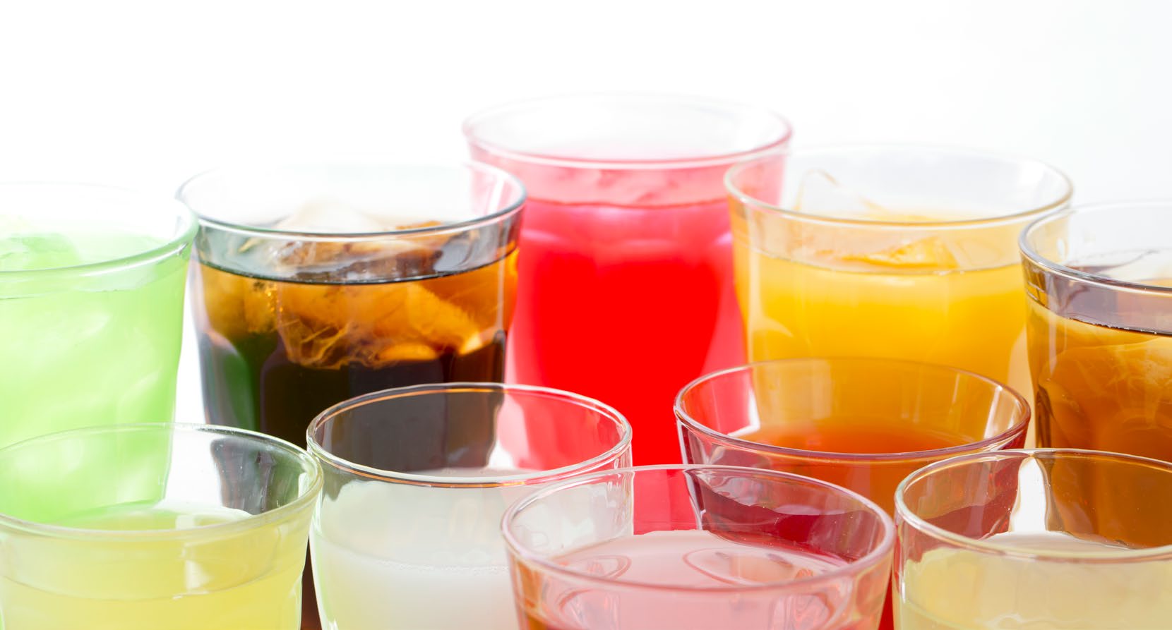 An assortment of glasses filled with brightly coloured fountain drinks over ice